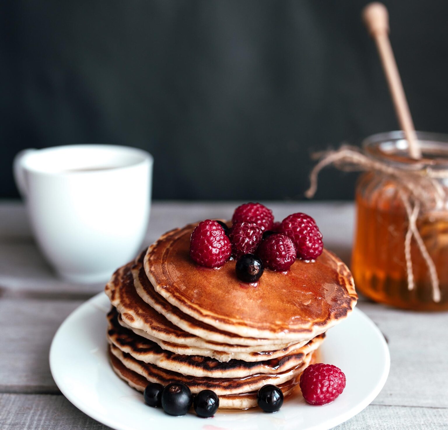 pancakes-with-berries-and-honey-on-a-white-plate-2021-08-31-12-20-35-utc.jpg